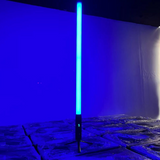 It features 192 RGBWA LEDs for full-color 360° illumination, with an IP65-rated aluminum housing, 9600mAh battery, wireless DMX control, and OLED display for versatile outdoor lighting setups. About 1.5 meters (59" inches) tall. Resembles a lightsaber.