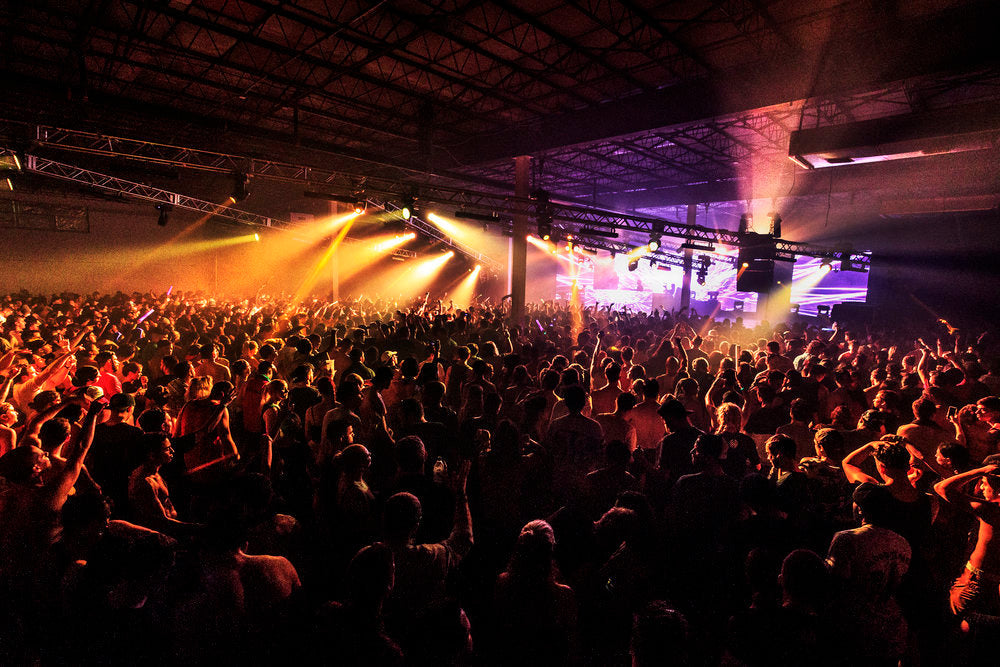 Indoor crowd concert with different lights being used.